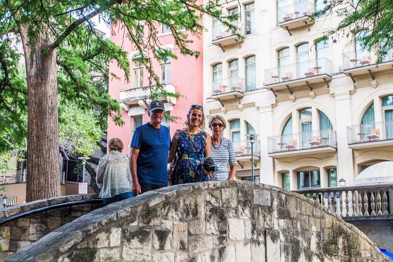 caz with her mum and dad posing on the arched bridge san antonio