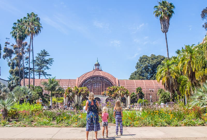 woman and girls looking astatine  the botanical gardens and buildings Balboa Park