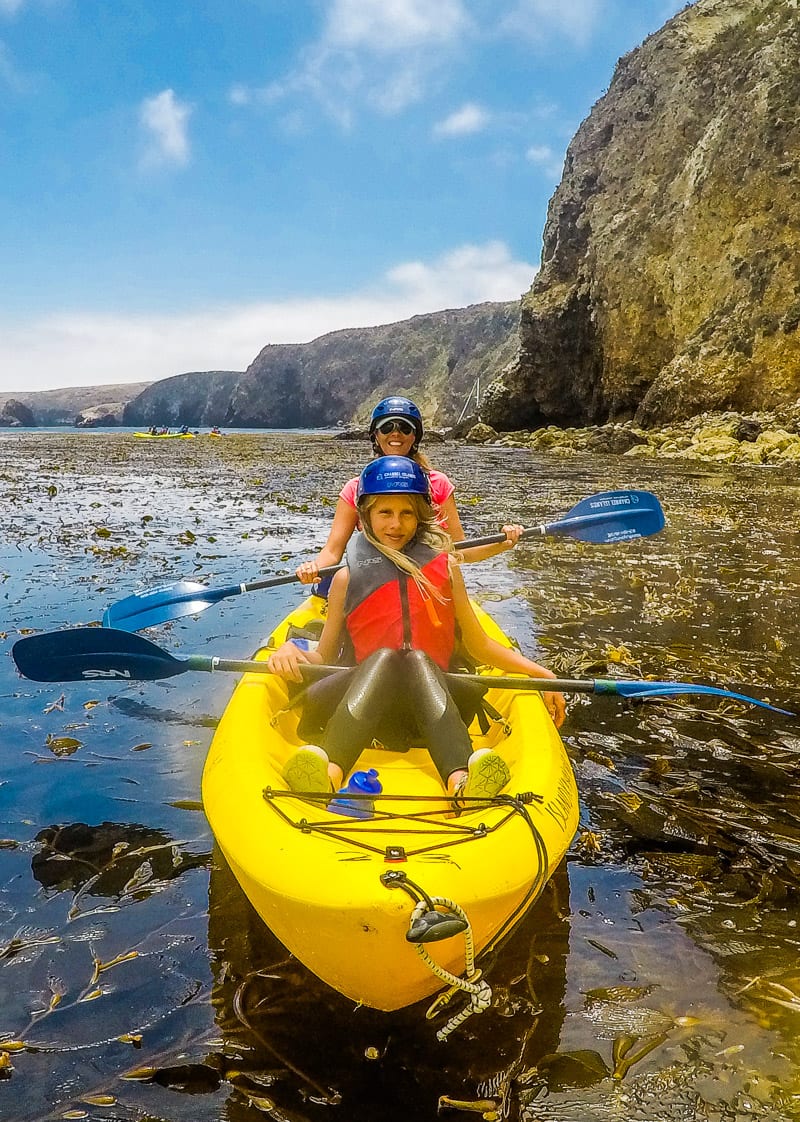 Caz and Kalyra kayaking next to cliffs