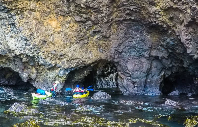people kayaking in a cave
