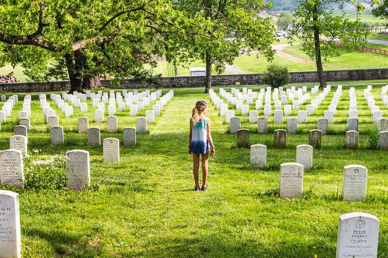 girl standing near headstones in Gettysburg national cemetery 