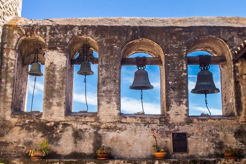 bells in a line in stone arches at San Juan Capistrano Mission