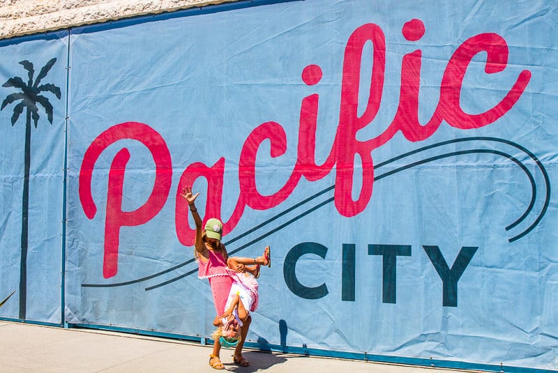 girls posing in front of Pacific City, sign