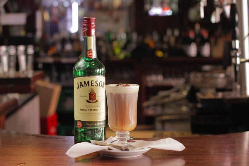 Irish coffee and jameson bottle on bar