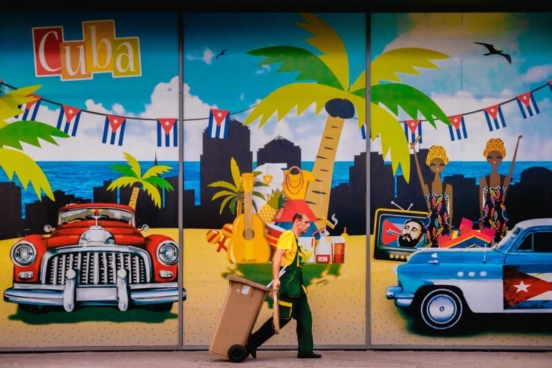 person walking in front of mural in cuba
