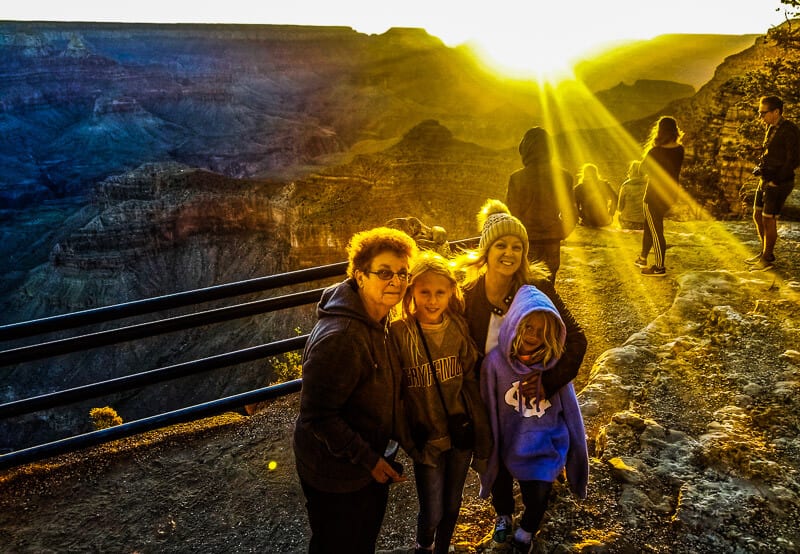 family posing at sunrise in grand canyon