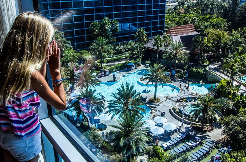 girl looking out of a window at disneyland resort pool