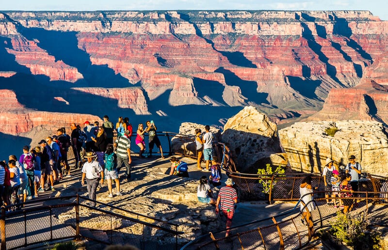 people standing on viewpoint looking at Grand Canyon views