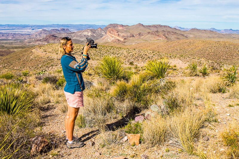 woman holding a camera in the desert