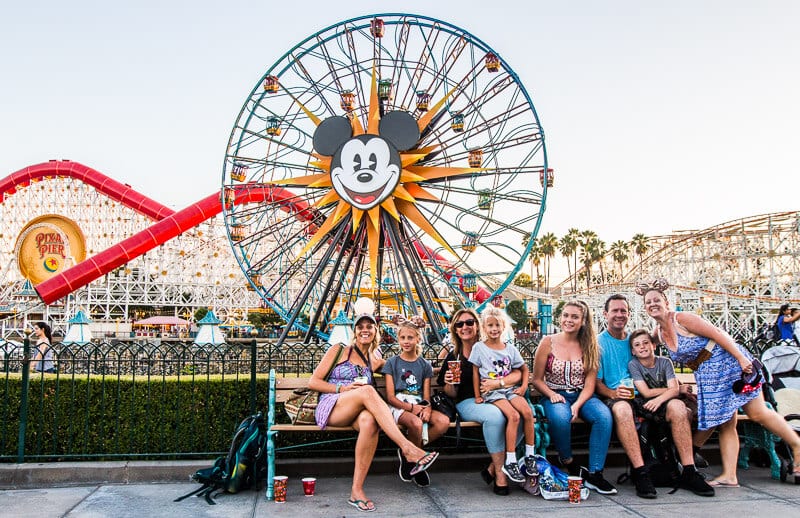 family posing in front of Ferris wheel Disney California Adventure Park