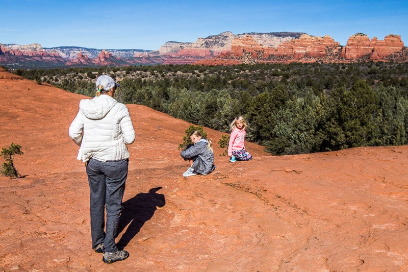 people walking on red rocks in a canyon