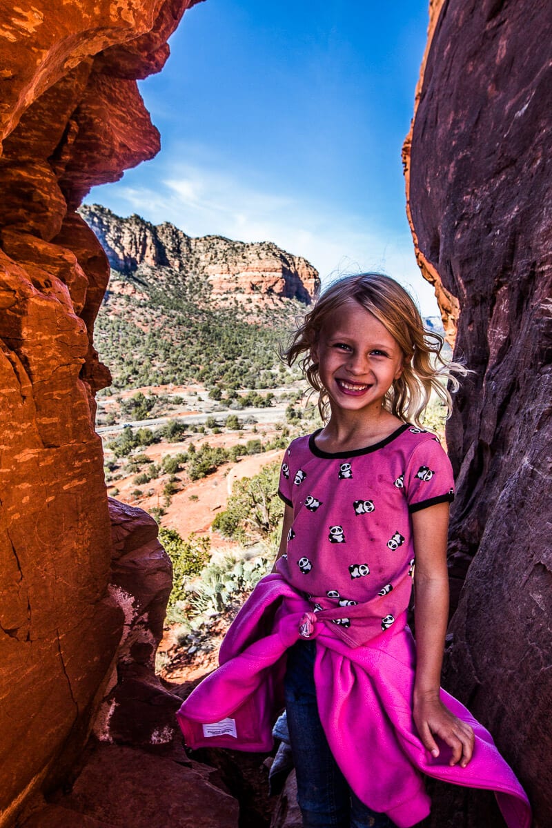 girl posing in gap between rocks 