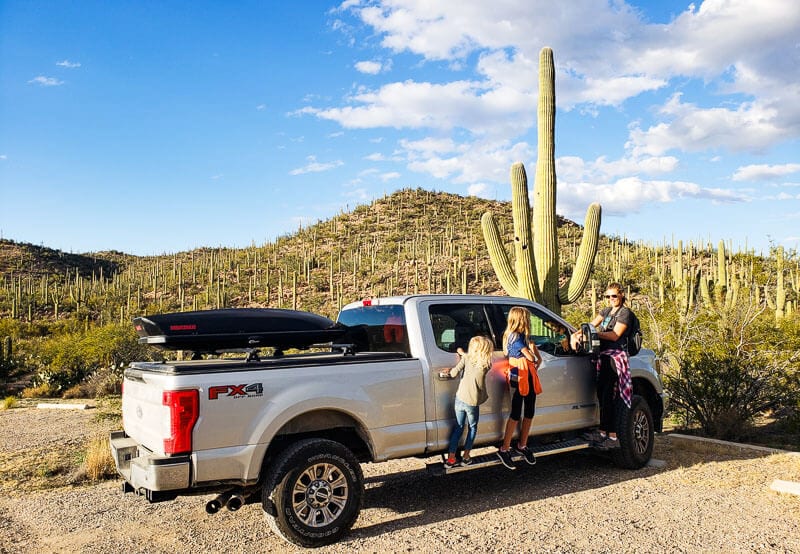 caz and grils standing next to truck and big cactus