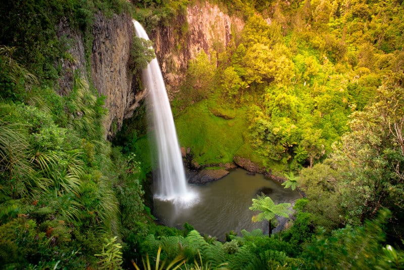 Bridal Veil Falls spilling over the cliff in the lush forest