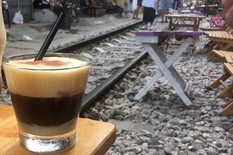 egg coffee on table beside train tracks