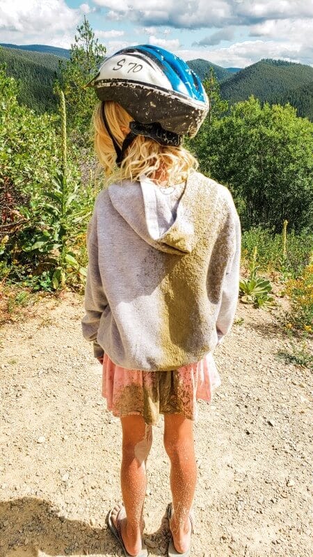 a child with mud splashed over the back of her clothes