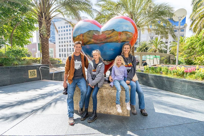 people sitting in front of a heart statue
