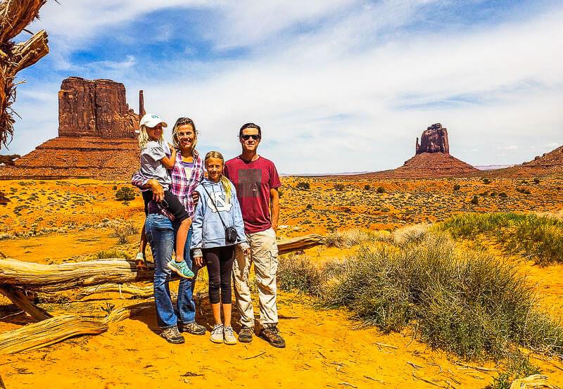 family standing in front of the mitton shaped rocks in Monument Valley
