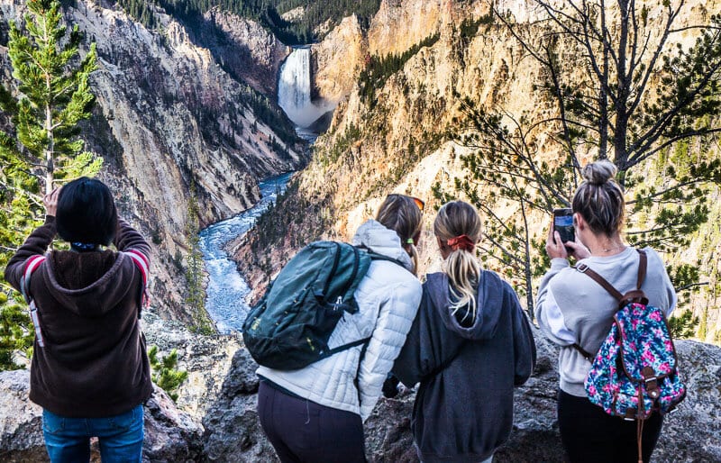 people looking at mountains with a waterfall