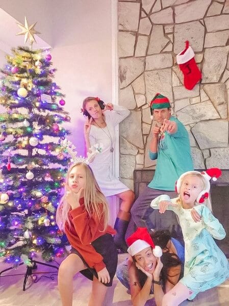 people posing in front of a christmas tree