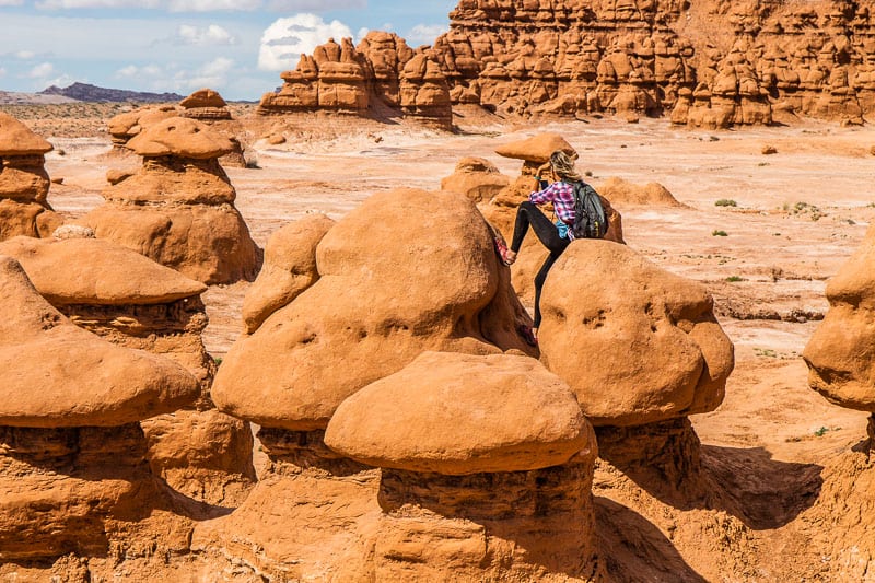woman standing on a large red rock