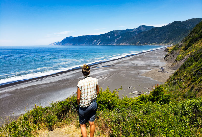 woman looking at view of black sand beach Lost Coast scenic drive