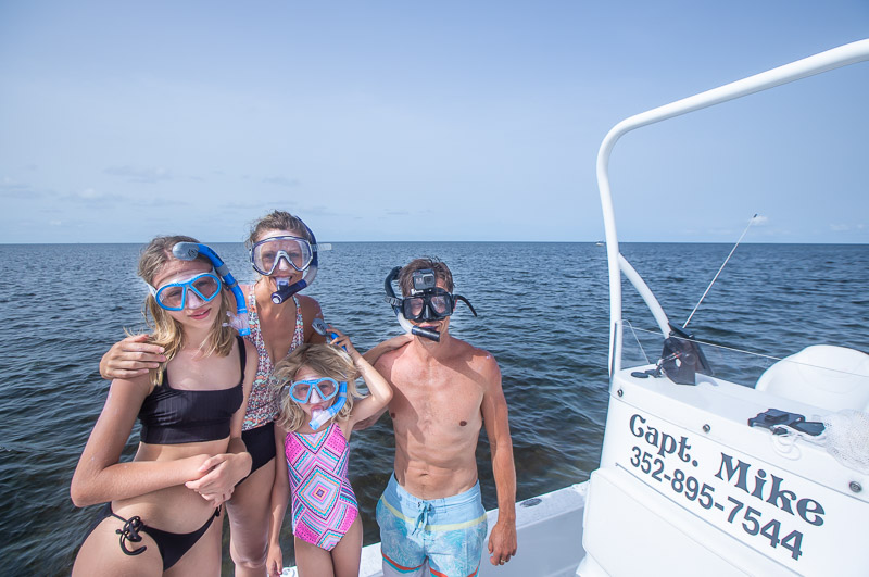 family with masks on a boat