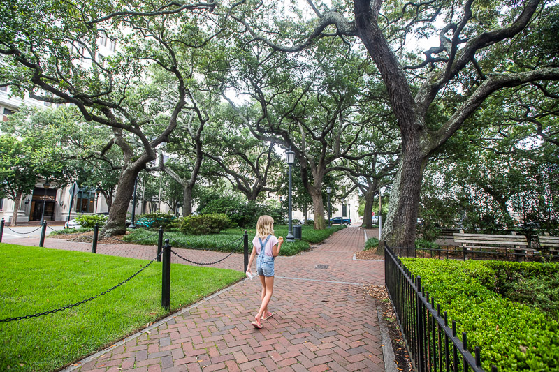 girl walking through savannah square under trees