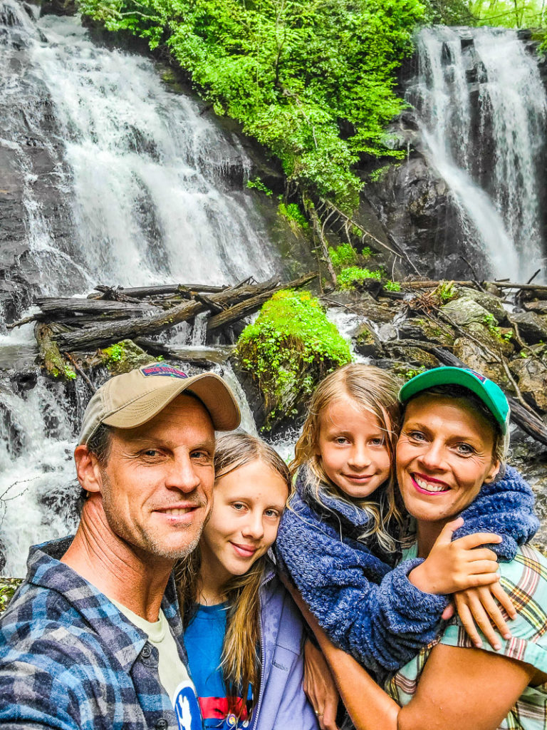 family posing in front of anna ruby falls