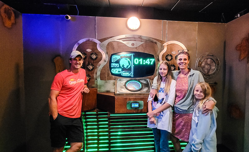 family smiling at camera at the Escape Room at Massanutten