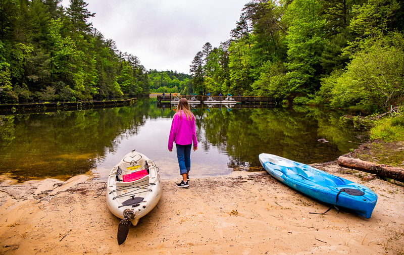 girl standing by kayaks at unicoi lake 
