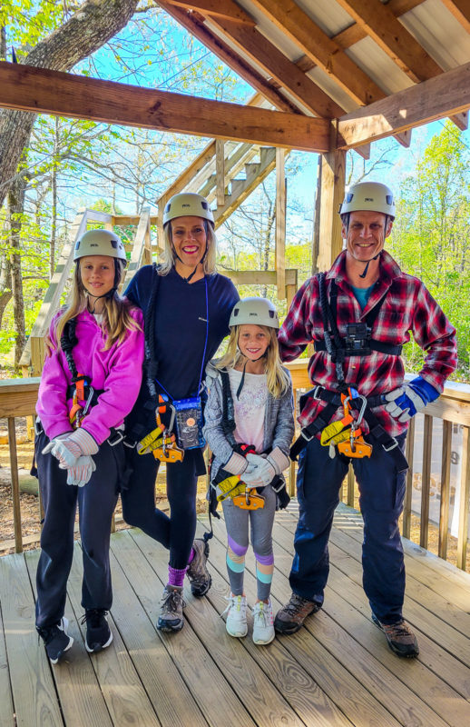 family posing with zipline gear 