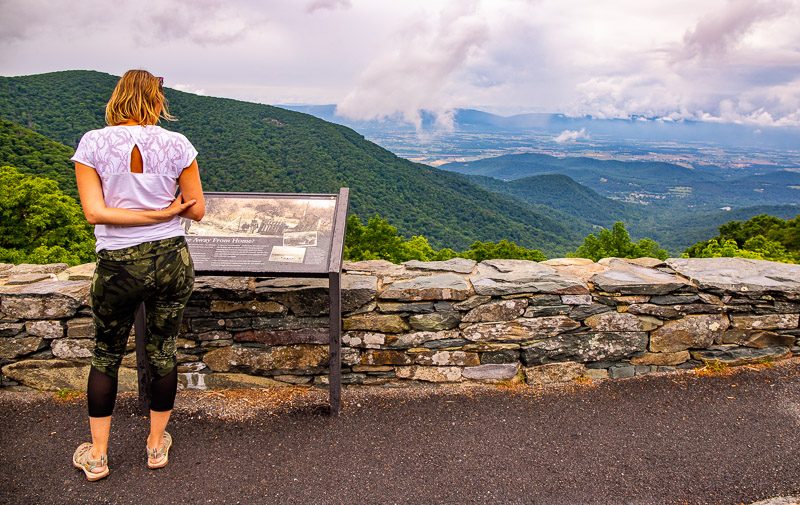 woman reading a sign on a mountain
