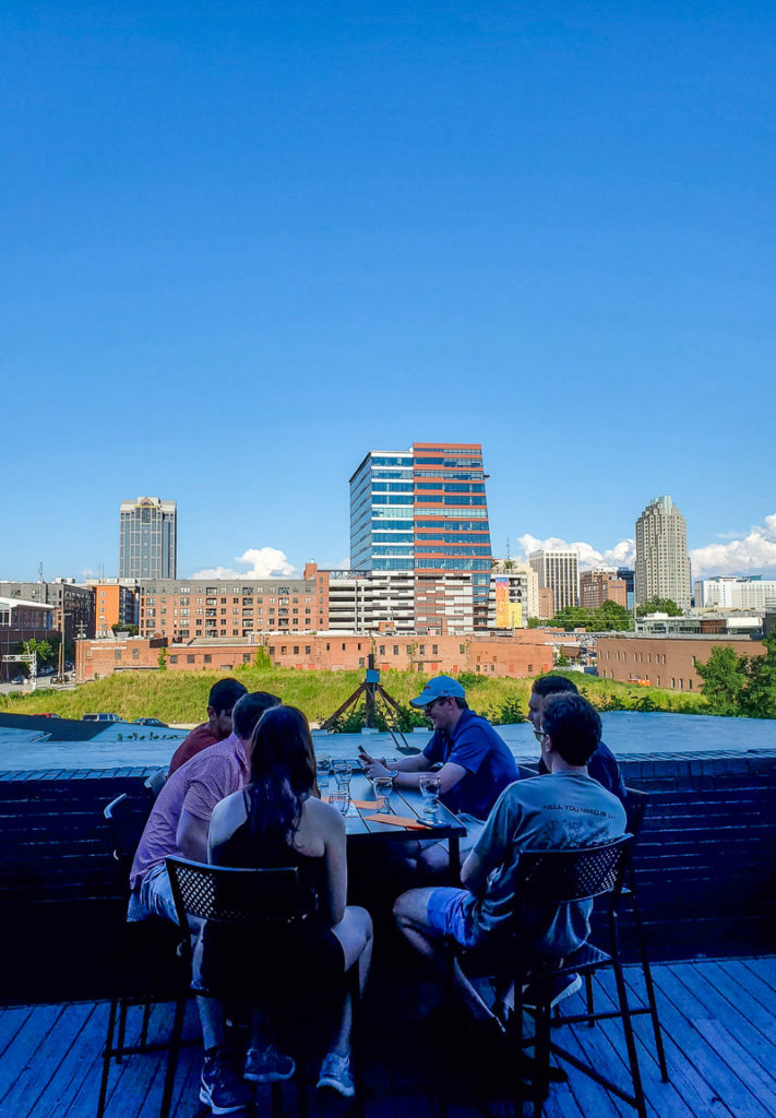people sitting at table with views of downtown raleigh
