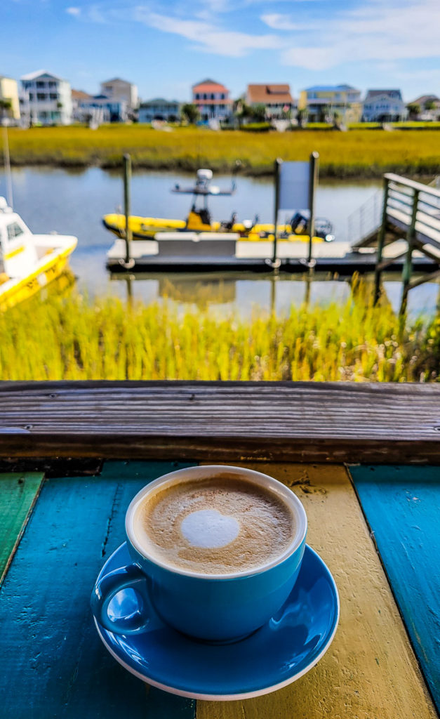 coffee on bench with waterway behind it