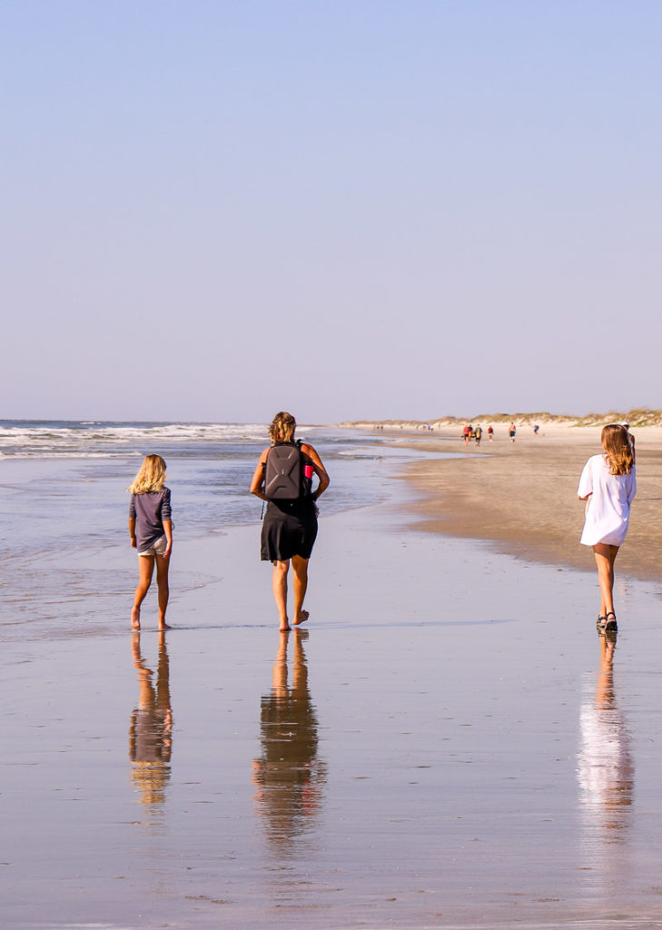 woman and dtwo girls walking along the beach at Bird Island, North Carolina