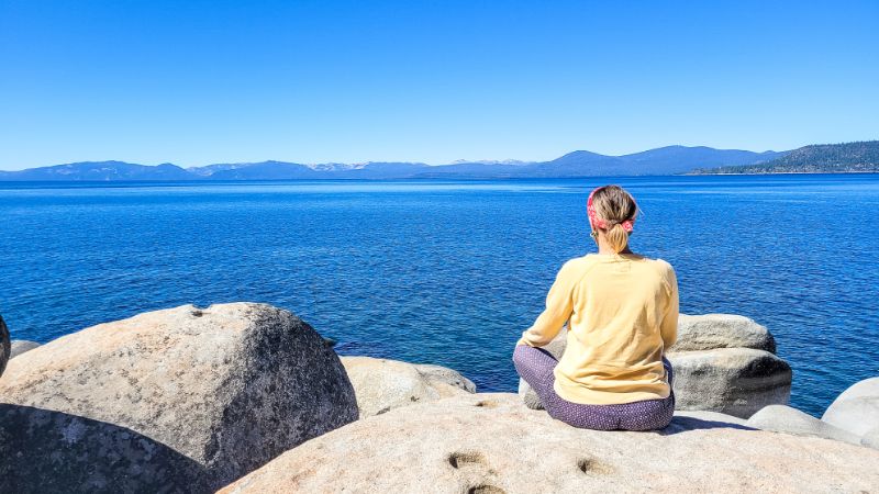 woman sitting on a rock overlooking the ocean