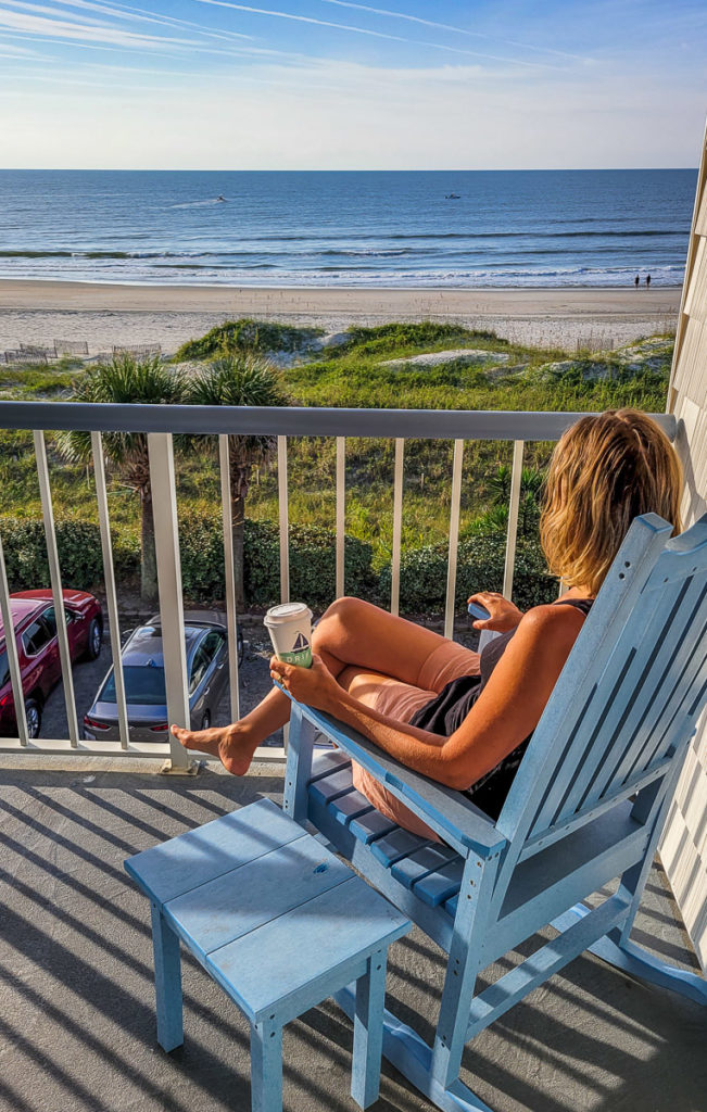 woman sitting on a balcony looking at the ocean
