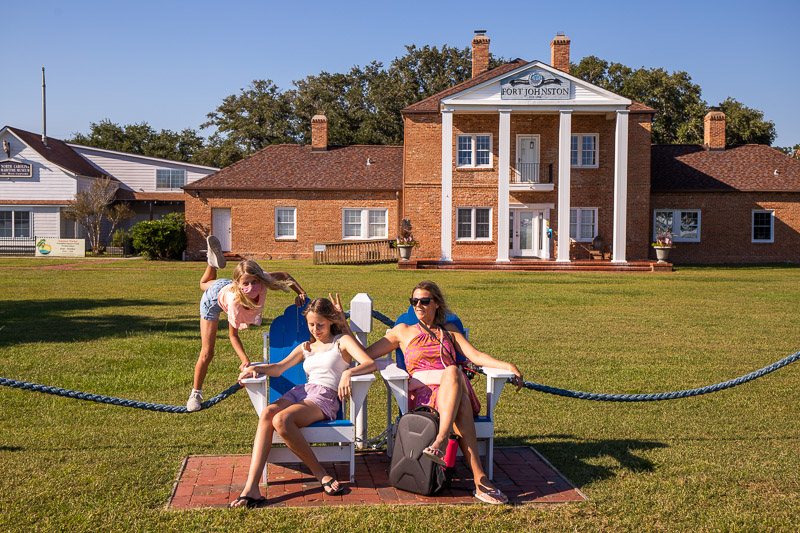 people sitting in chairs in front of a brick house