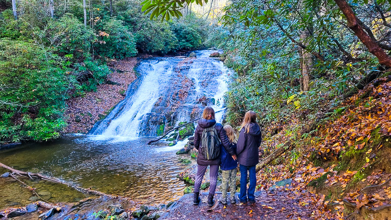 people standing next to a waterfall