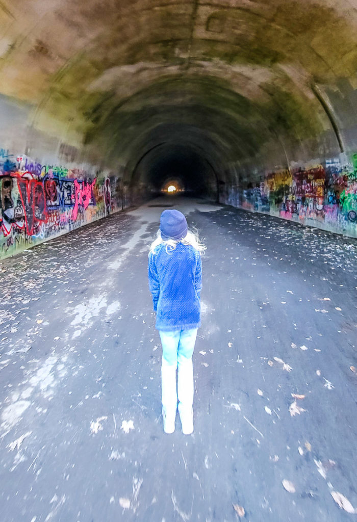 girl walking through a tunnel