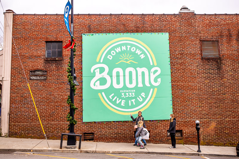 people standing in front of boone mural 