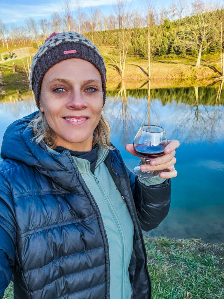 woman posing for a picture holding a glass of wine