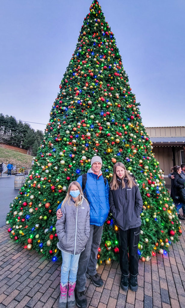 people standing in front of a christmas tree