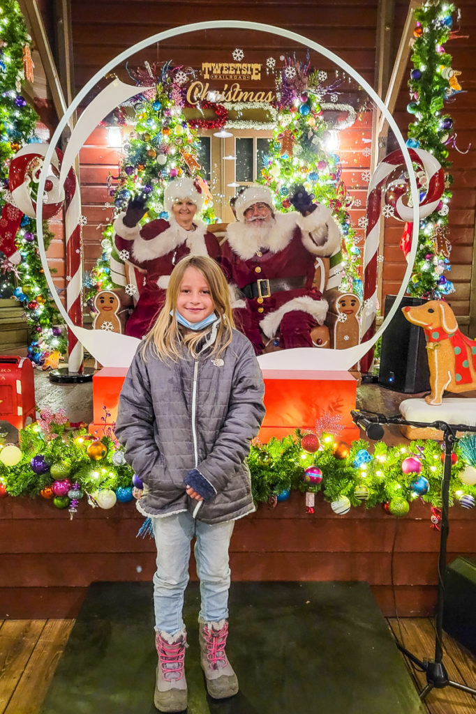 girl standing in front of christmas decorations