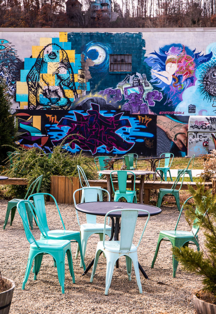 tables and chairs in front of a mural