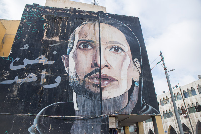 street art mural of man and woman face merged as one