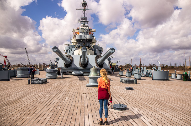 girl looking at guns on USS North Carolina battleship top things to do in North Carolina