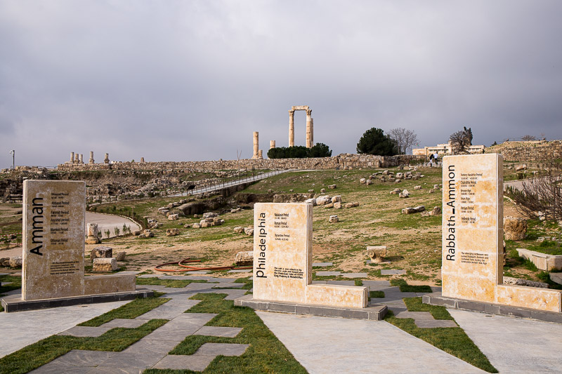 ancient ruins of the citadel with three plaques showing the three names of amman