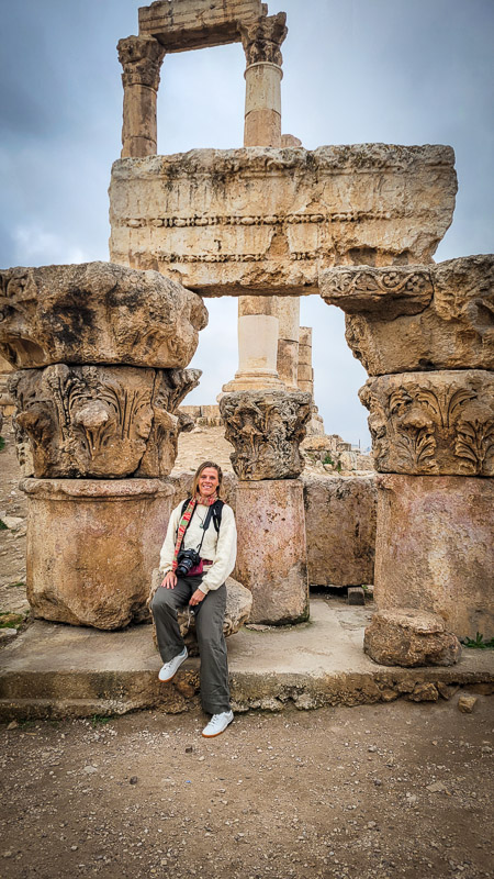 caz sitting in front of ruins in citadel amman